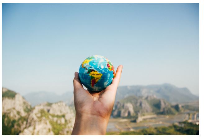 Hand holding a small globe