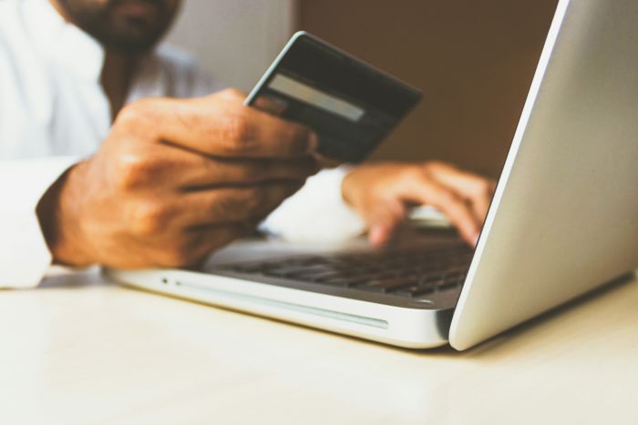 man shopping with creditcard in front of computer