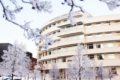 JIBS building, snowy trees in foreground