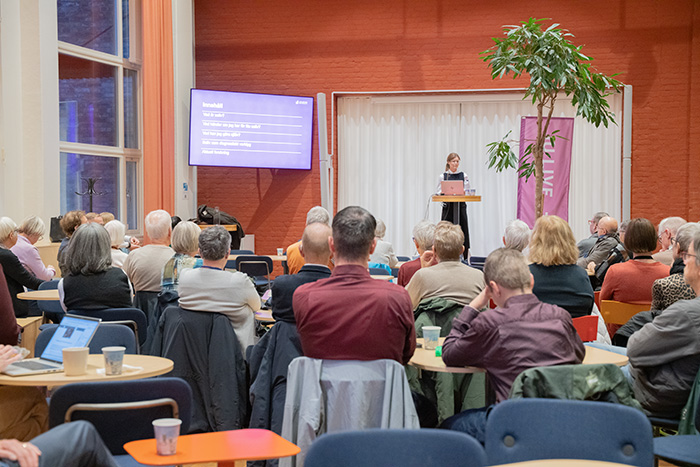 Publik bakifrån med Malin Stensson på scenen.