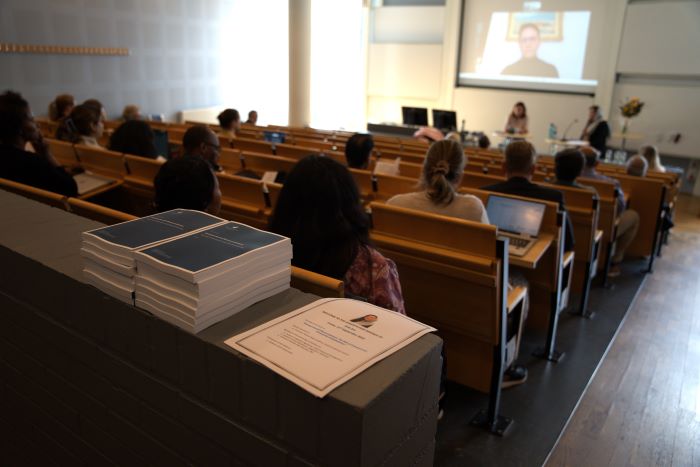 Photo of the audience attending Rida Ijaz’s dissertation defence at JIBS, with printed theses visible in the foreground