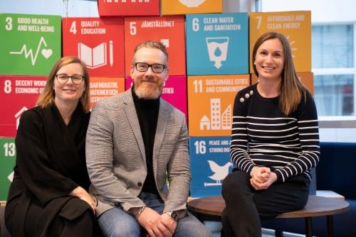 CEnSE directors, Mikaela Backman, Johan Klaesson and Sofia Wixe, sitting in the JIBS lobby, smiling towards the camera. 