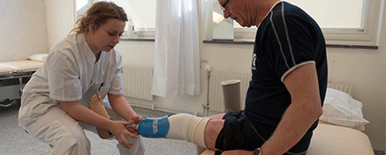 Kvinna hjälper patient med protes