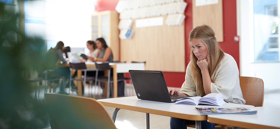 Student sitting with laptop in the library