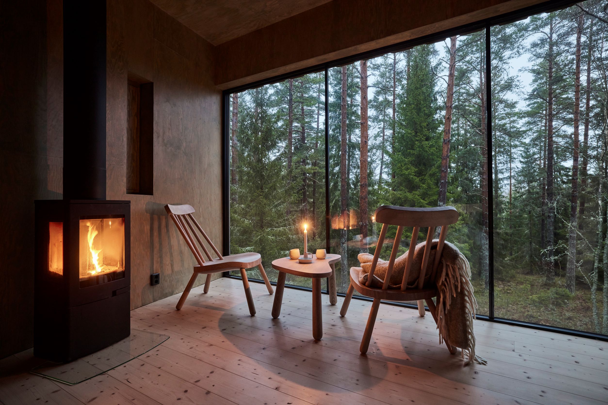 The spindle chairs and tables made by the students are placed in front of the panoramic windows at Trakt Forest Hotel.