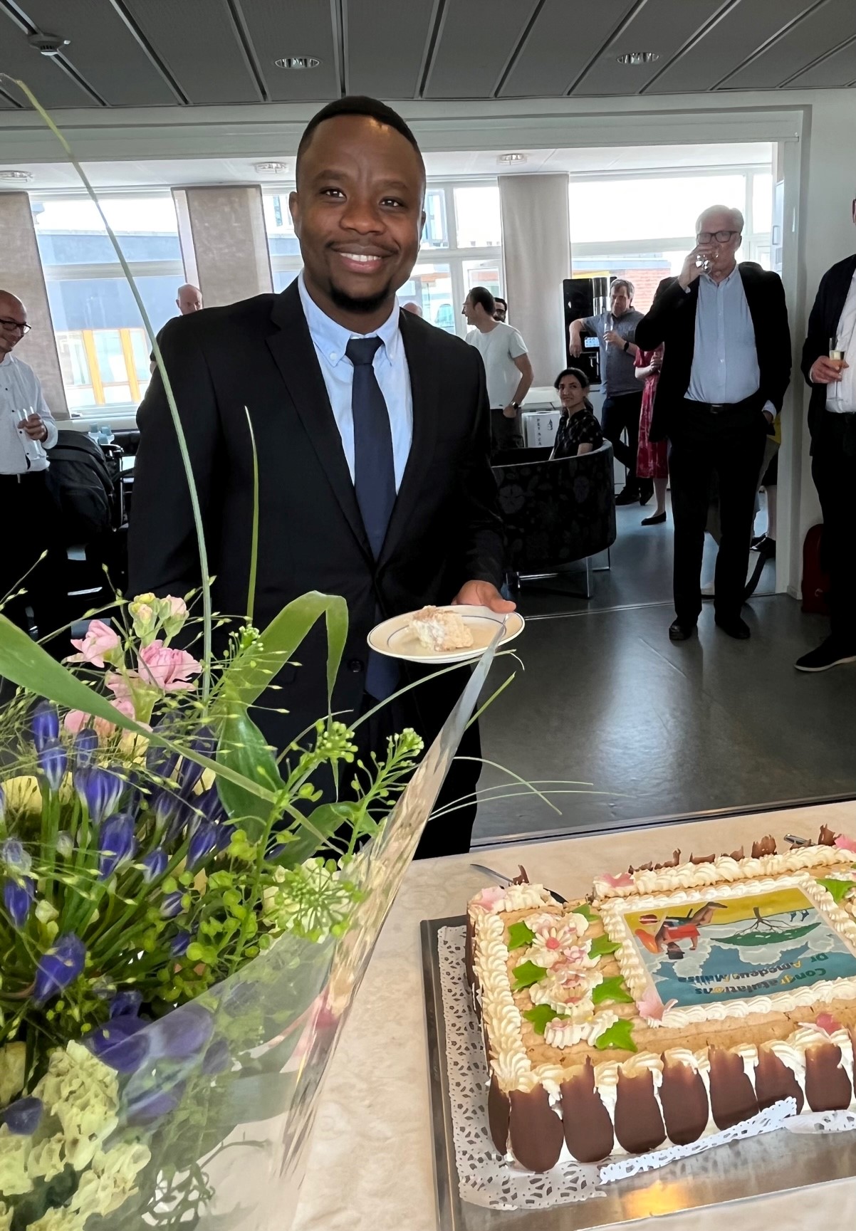 Amedeus Malisa  with flowers and cake