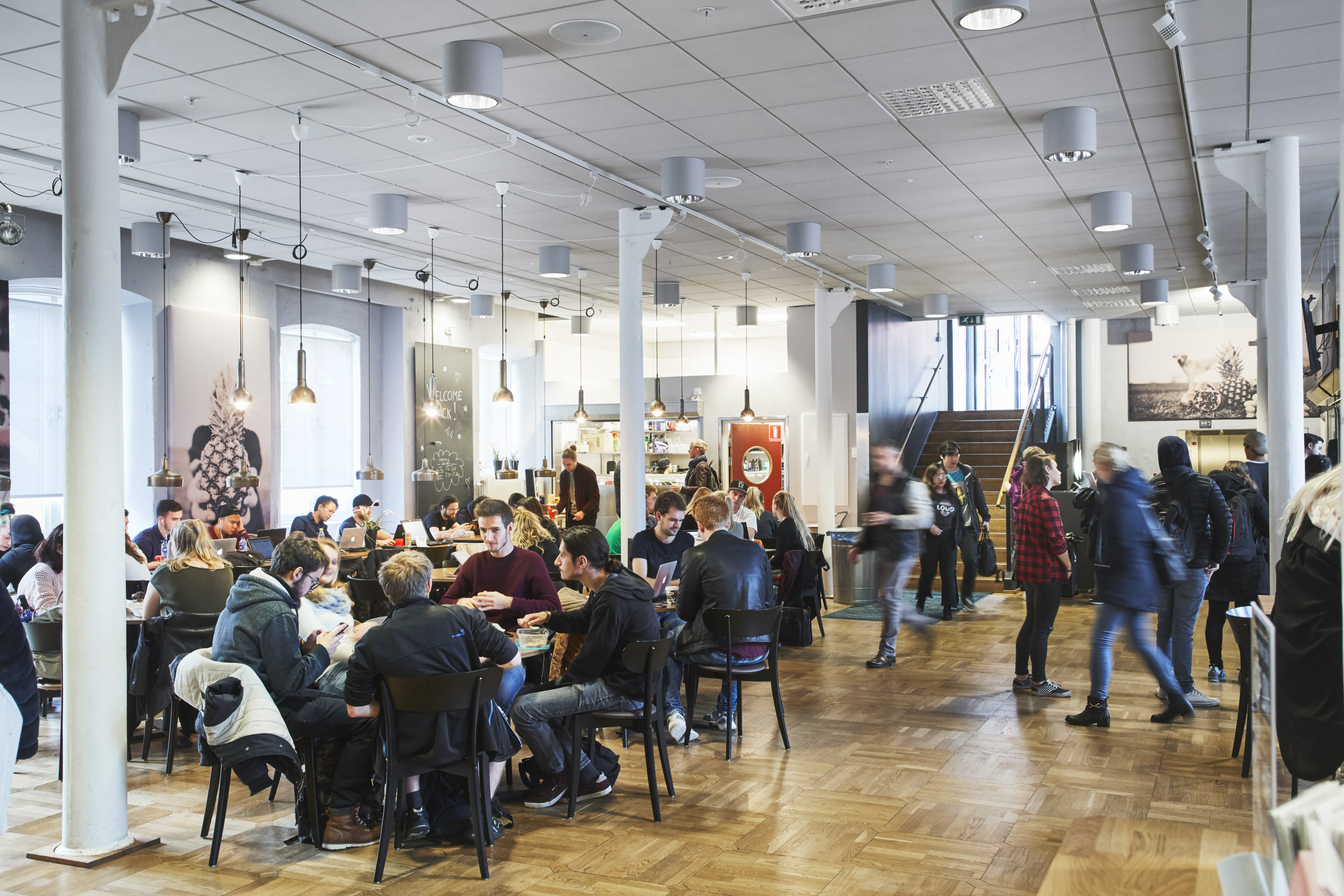 Studenter som sitter vid cafébord i studenternas café